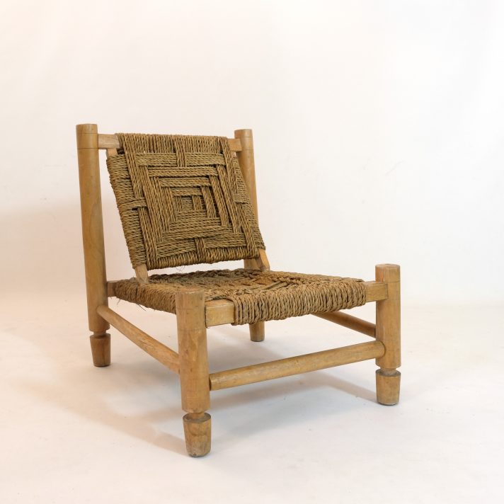 Fauteuil bas en bois naturel et corde tressée.