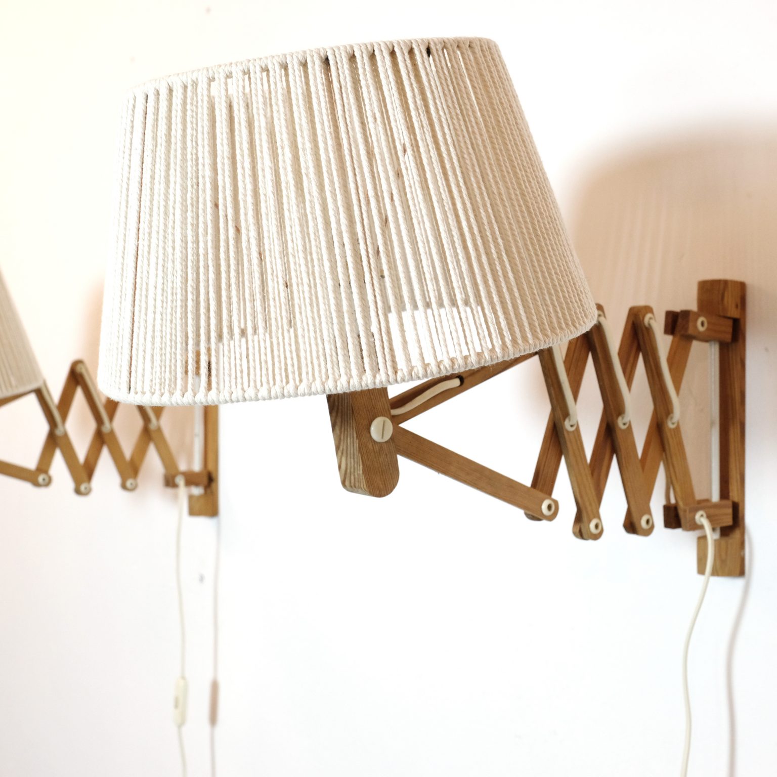 Pair of wooden wall mounted scissor lamps with cotton shades. — LampAndCo
