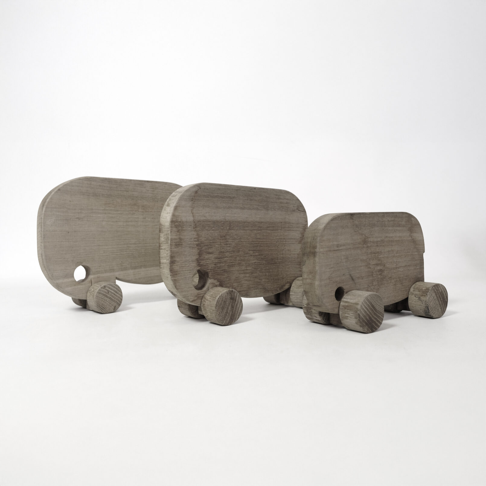 Set of three wooden vintage elephants on wheels.