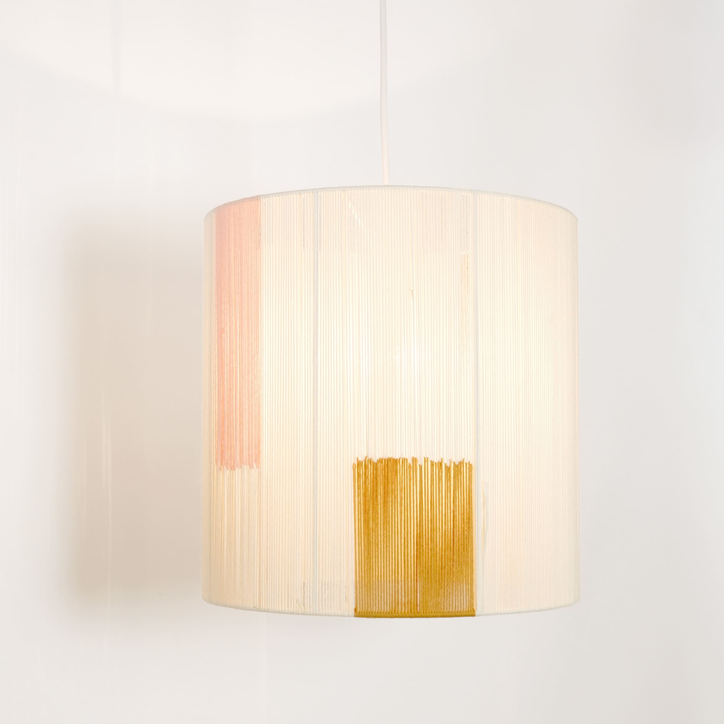 Suspension en fil de coton ecru, rose et camel.