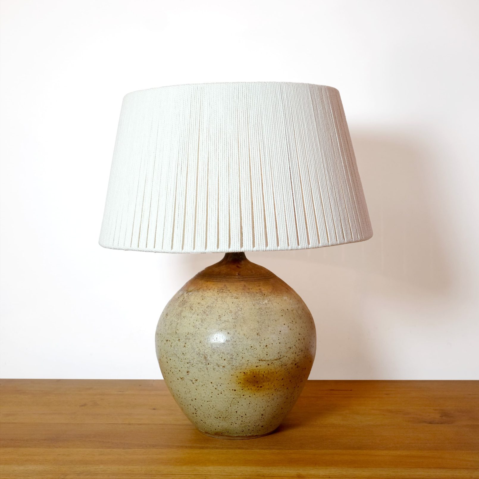 Large stoneware table lamp with a cotton shade.